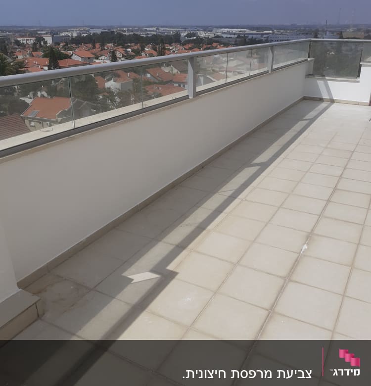 מרפסת עם מעקה זכוכית ורצפת אריחים